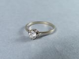 une photo en gros plan d'une bague en diamant posée sur une surface bleue