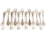 six forks are lined up in a row on a white surface