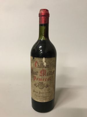 une vieille bouteille de vin posée sur une table blanche