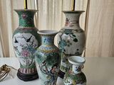 four vases sitting on a table with a lamp on top of them