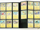 beaucoup de cartes Pokémon dans un classeur posé sur la table