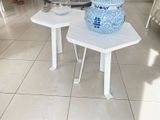 a white table with a blue vase on top of it