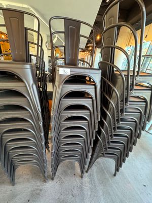 de nombreuses chaises empilées les unes sur les autres dans une pièce