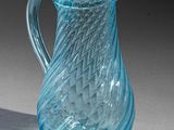 a blue glass pitcher that is sitting on a table