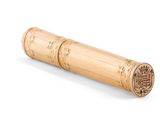 un tube de bambou posé sur une surface blanche