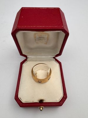 an image of a gold ring in a red box on a white surface
