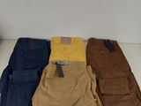 five pairs of men ' s cargo pants sitting on a white surface