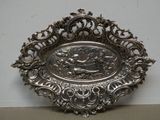 une assiette en argent sur laquelle est représenté un homme et une femme