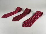 three red neck ties sitting next to each other on a white surface