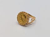 a close up of a gold ring with a coin on it
