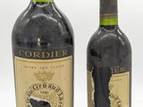 deux bouteilles de vin posées l'une à côté de l'autre sur une surface blanche