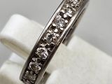 a close up of a ring with diamonds on a white surface