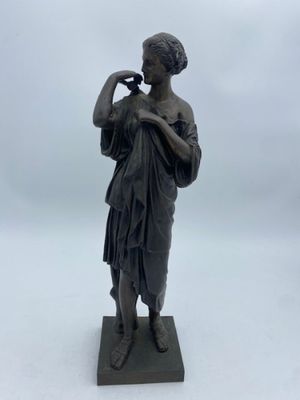 bronze statue of a woman drinking from a bottle