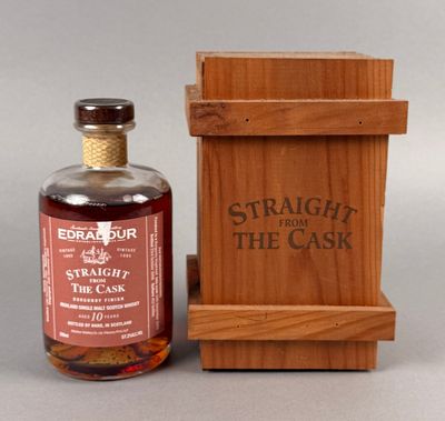 une bouteille de whisky « straight from the cask » à côté d'une caisse en bois