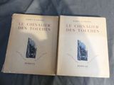 two books sitting on top of a bed next to each other