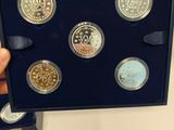 a person holding a set of six coins in a box