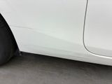 the side of a white car with a flat tire on the road