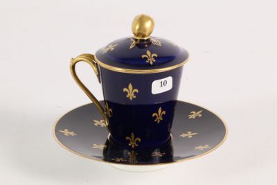a blue cup and saucer with a gold decoration on it