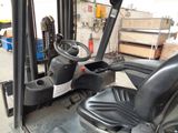 a forklift with a steering and a seat in the back of it