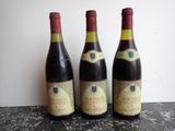 three bottles of wine sitting on a table next to each other