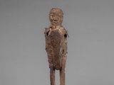 a small wooden statue of a man with a face and arms