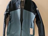 une veste bleue et noire accrochée à un cintre sur un mur