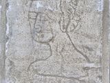 une image représentant une plaque en pierre sur laquelle figure le visage d'une femme