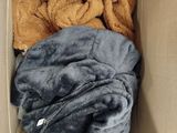 a box full of blankets and blankets sitting on a couch