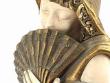 statue of a woman holding a fan and a fan in her hands