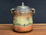 a vase with a lid that has a painting on it