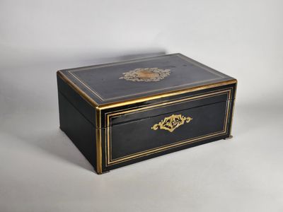 une boîte à bijoux ancienne, noire et dorée, ornée de motifs dorés
