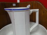 a white coffee pot sitting on top of a stack of plates