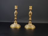 paire de chandeliers anciens en laiton sur table noire