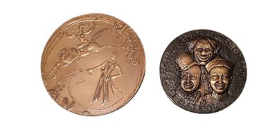 deux médailles de bronze représentant un homme et une femme sur fond blanc