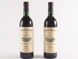 two bottles of wine sitting next to each other on a white surface
