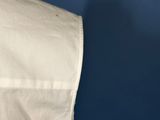 a close up of a white umbrella with a blue sky in the background