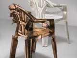 a white chair and a brown chair sitting next to each other