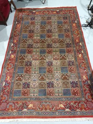 an image of a rug on a white floor with a red chair in the background