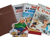 several cartoon books are stacked on top of each other on a white surface
