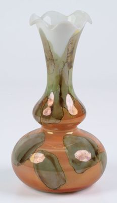 a glass vase with a flower on it sitting on a table