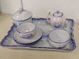 a blue and white tea set on a tray on a table