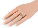 a woman ' s hand with a diamond ring on it