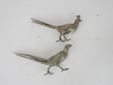 pair of silver plated pheasants on a white surface