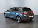 the rear end of a grey car in a white room