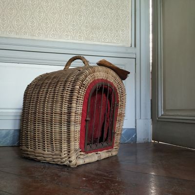 un panier en osier posé par terre devant une porte