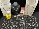 several necklaces, bracelets, and other jewelry are displayed on a table