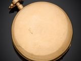 an antique gold pocket watch with a chain on a black surface