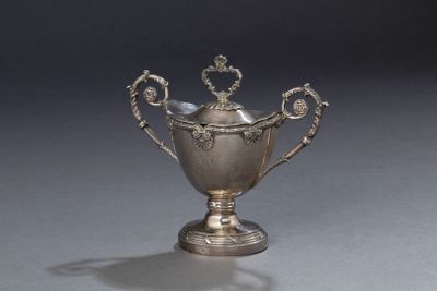 une coupe ancienne en argent, dotée d'anses, sur un fond gris