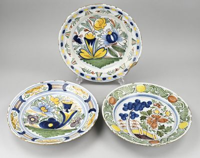 trois assiettes ornées de fleurs et de feuilles, posées sur une table