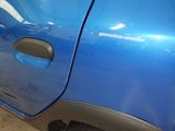 a close up of a blue car with a hole in the door
